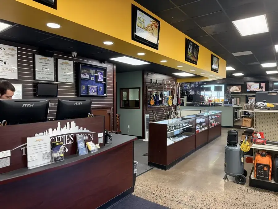 Twin Cities Gun & Pawn store interior — pawn counter, guitars, tools, and jewelry in the Twin Cities